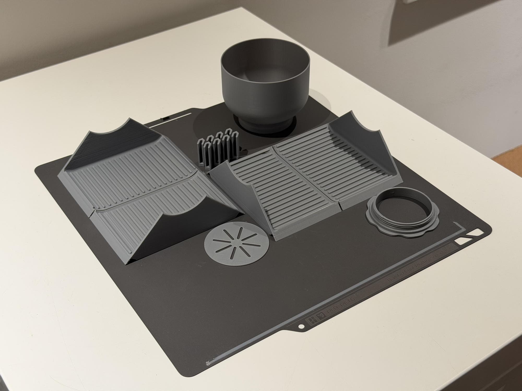 Parts of a gray 3D-printed concrete mold resting on the printer bed immediately after printing